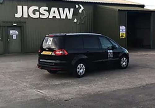A black K1 Security vehicle parked outside an industrial unit